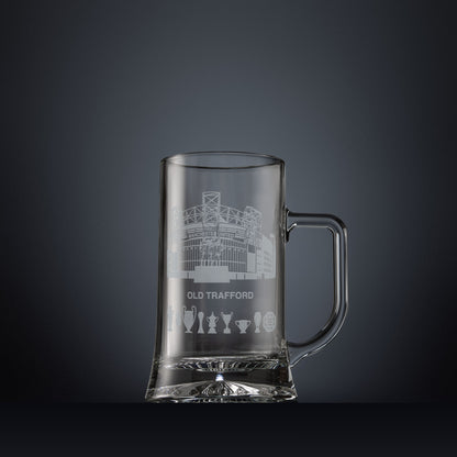 Glass tankard engraved with a line-art interpretation of Old Trafford stadium, with football trophy silhouettes beneath, inspired by its distinctive architectural form.