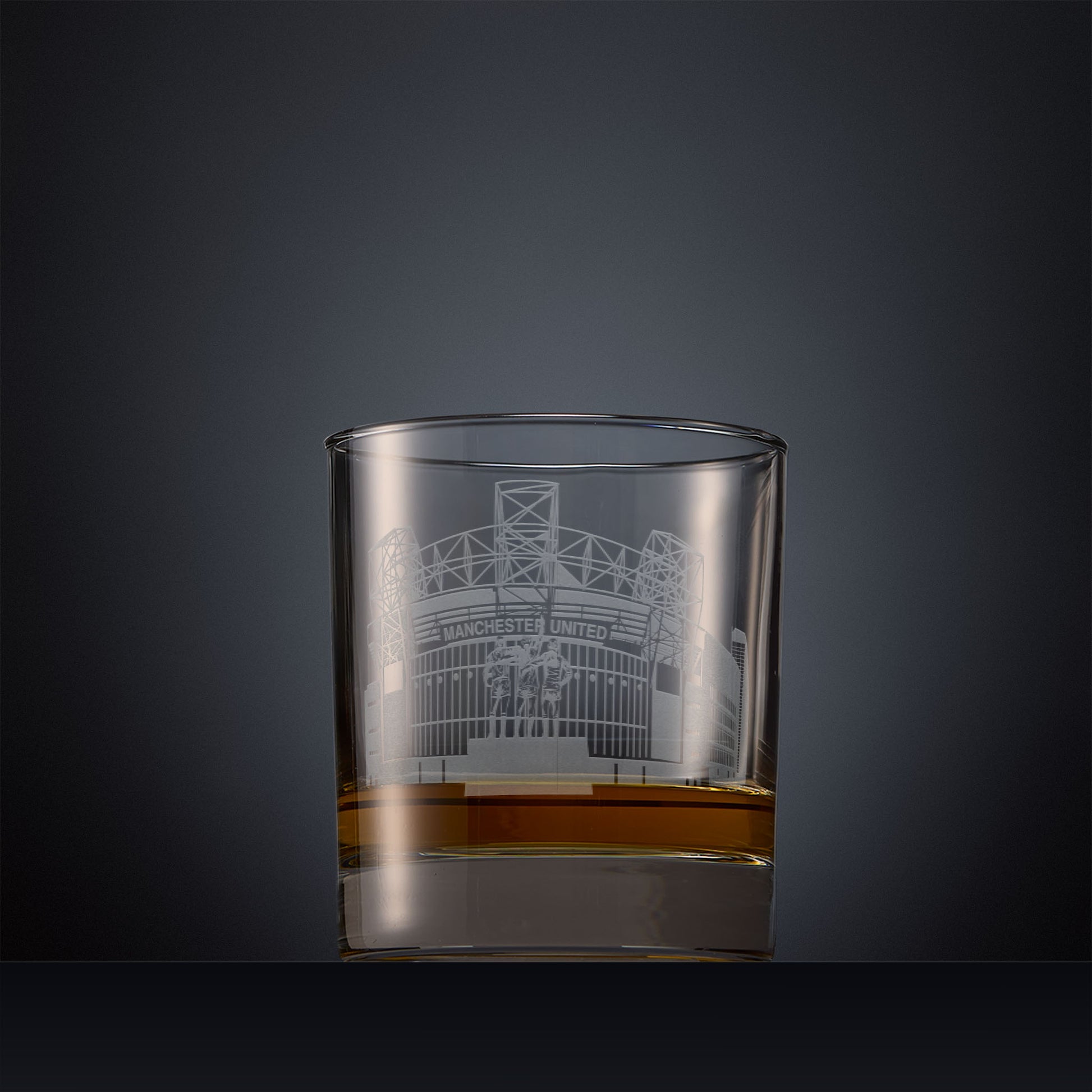 Engraved whisky glass with Old Trafford, Manchester's football stadium on a black background