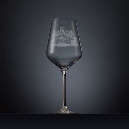 Engraved wine glass featuring a line-art illustration of Old Trafford stadium, shown on a dark background