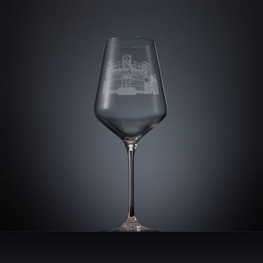 Engraved wine glass featuring a line-art illustration of Old Trafford stadium, shown on a dark background