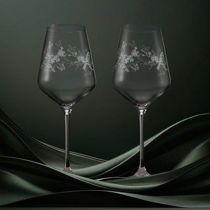 Two clear wine glasses featuring garden birds, blossom and butterflies in a wraparound design