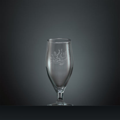 Engraved stemmed beer glass with a peacock, trailing leaves and feathers design