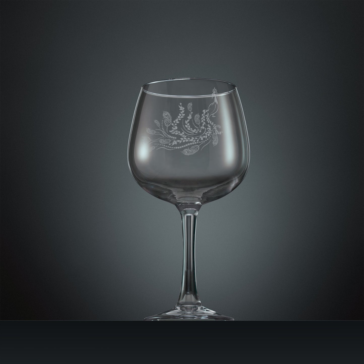 Engraved gin glass with a peacock, trailing leaves and feathers design