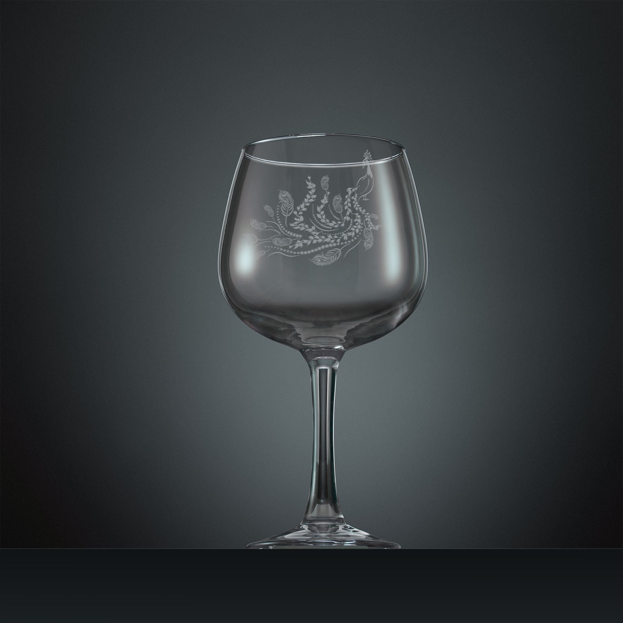 Engraved gin glass with a peacock, trailing leaves and feathers design