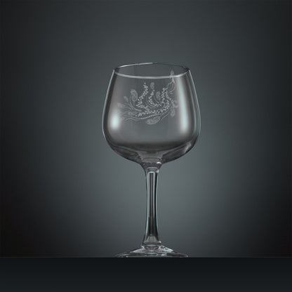 Engraved gin glass with a peacock, trailing leaves and feathers design