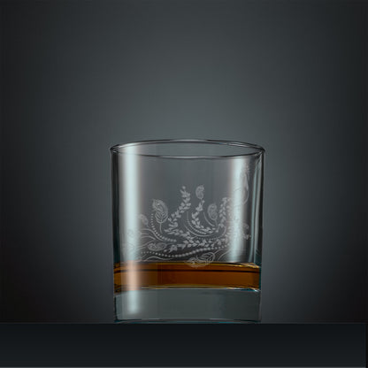 Engraved whisky glass with a peacock, trailing leaves and feathers design