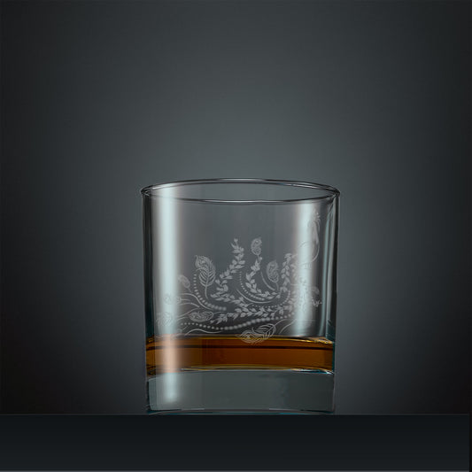 Engraved whisky glass with a peacock, trailing leaves and feathers design