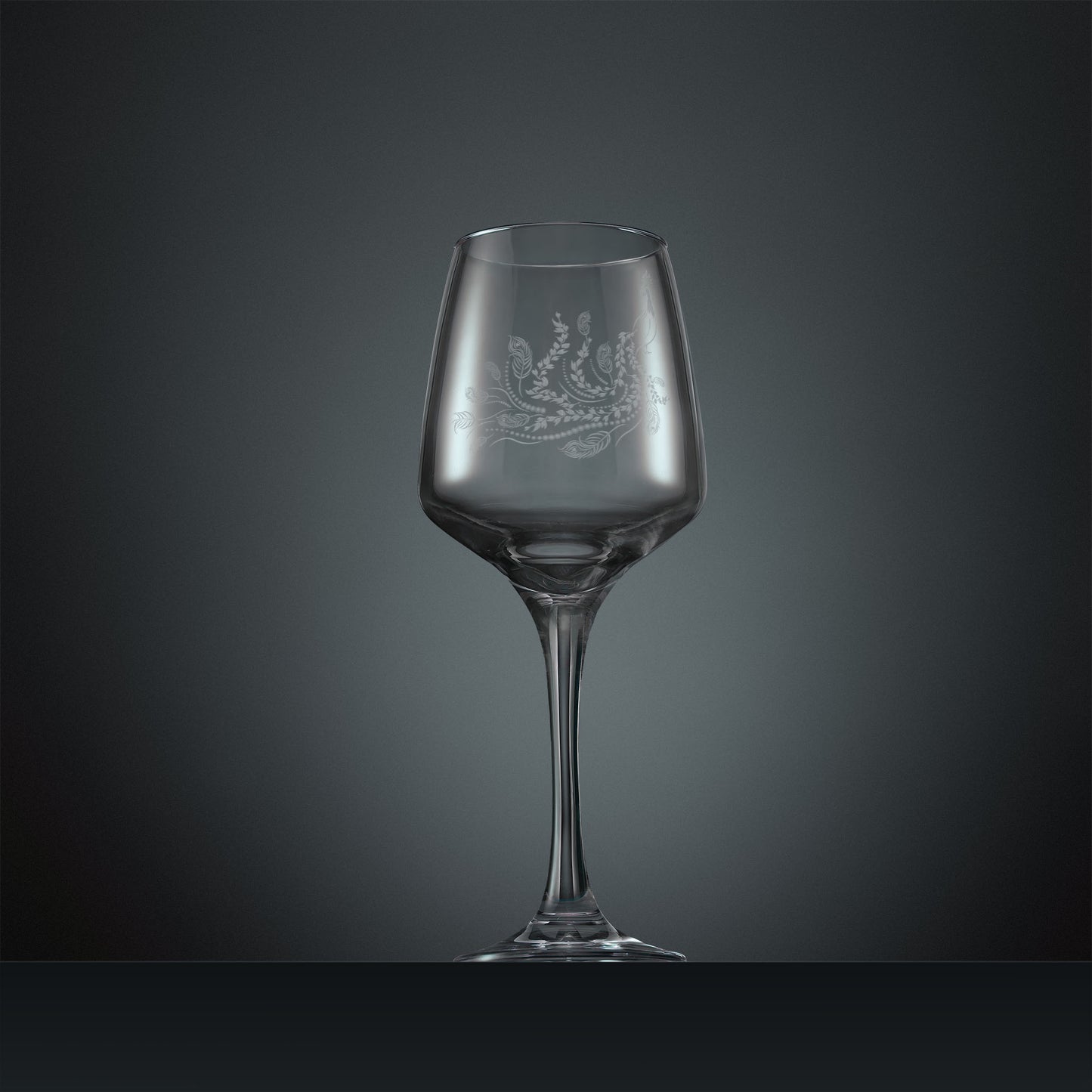 Engraved wine glass with a peacock, trailing leaves and feathers design