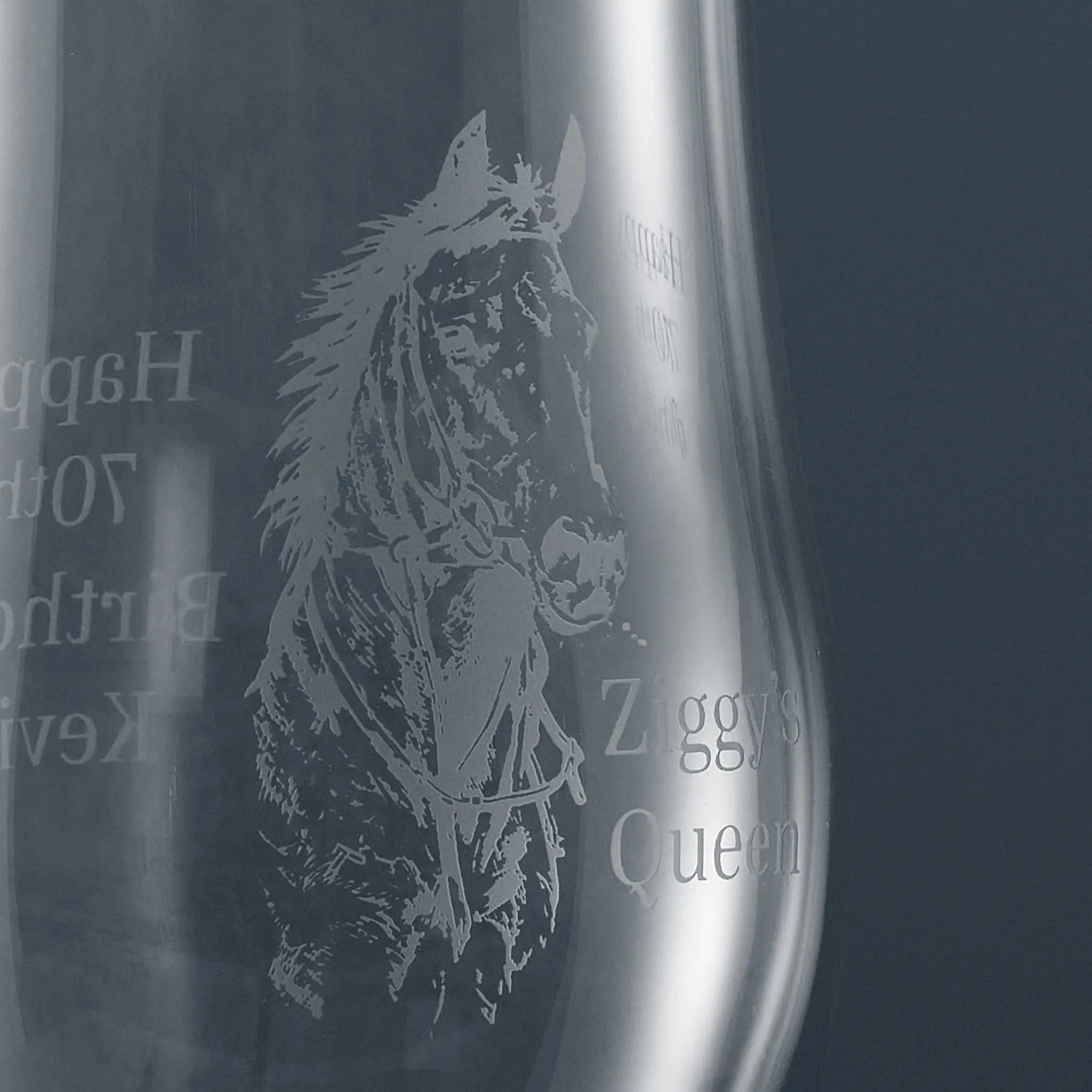 Close-up of engraved racehorse detail on stemmed beer glass, highlighting fine linework and hand-finished sandblast engraving on clear glass.