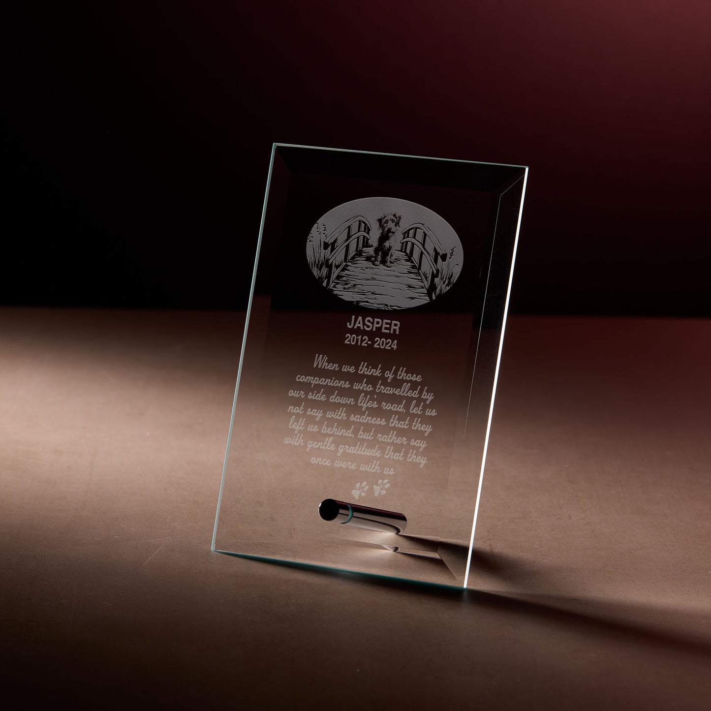 Engraved memorial plaque with rainbow bridge design and text.