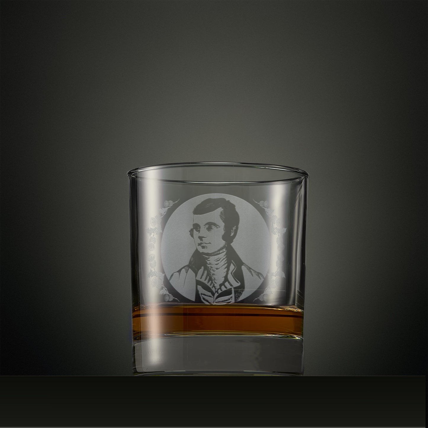 Engraved whisky glass with a portrait of Robert Burns surrounded by thistles