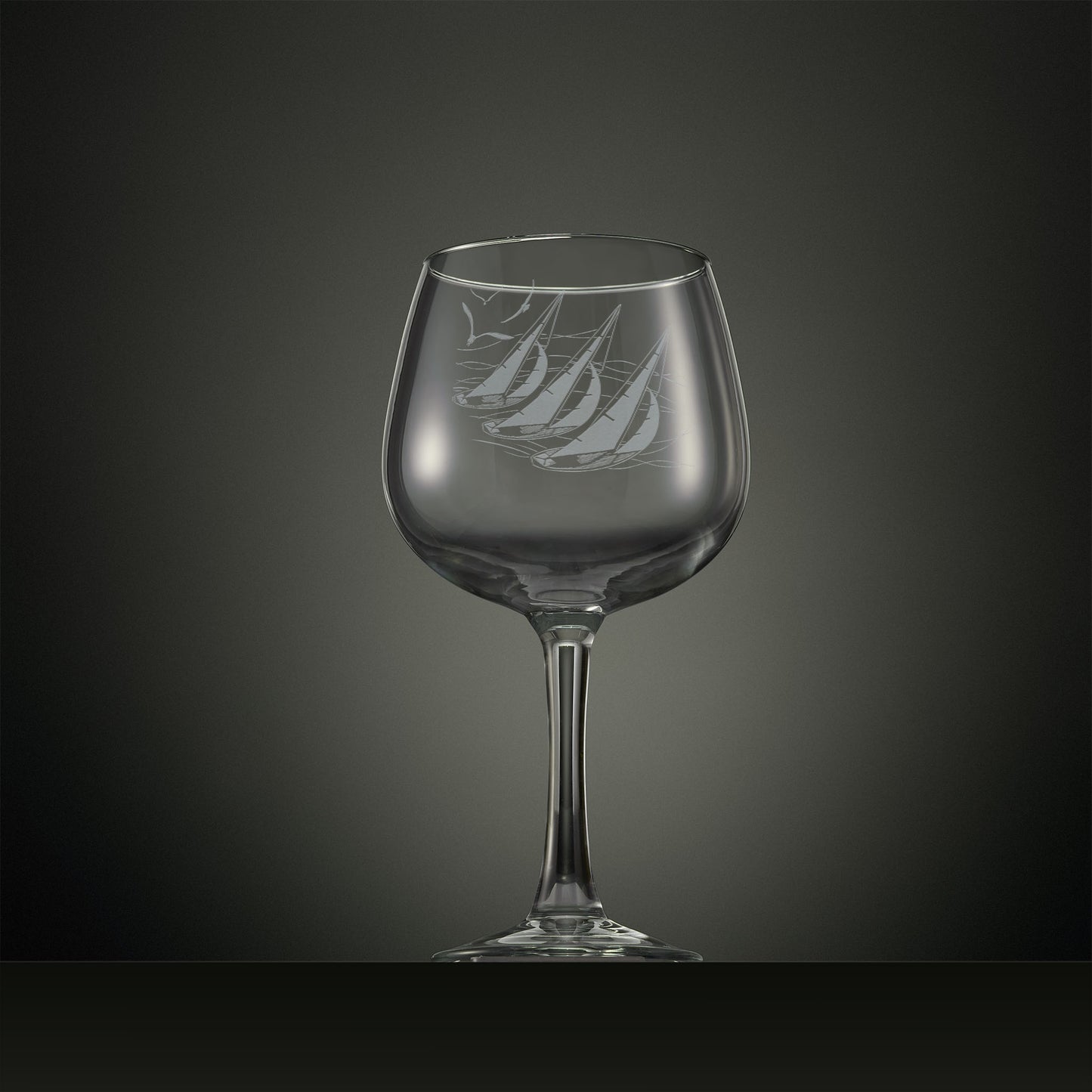 Engraved gin glass with three sailing yachts and seabirds overhead 