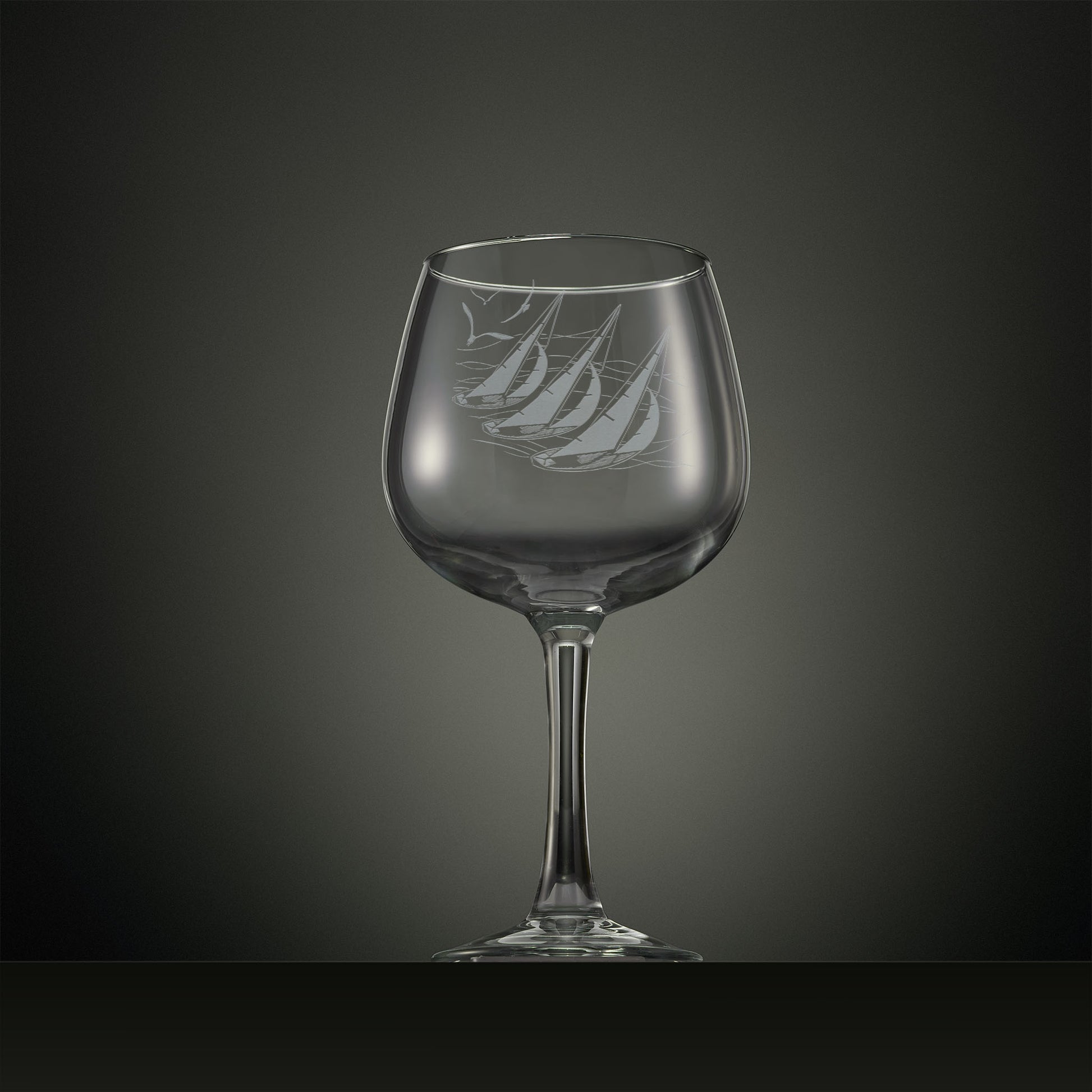 Engraved gin glass with three sailing yachts and seabirds overhead 