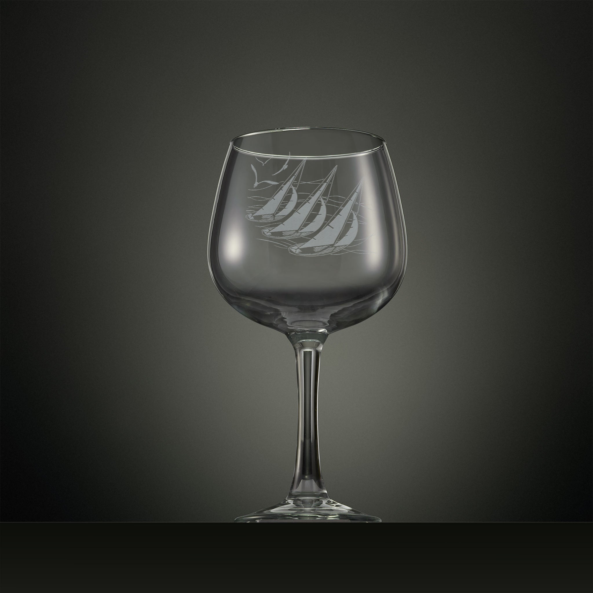 Engraved gin glass with three sailing yachts and seabirds overhead 