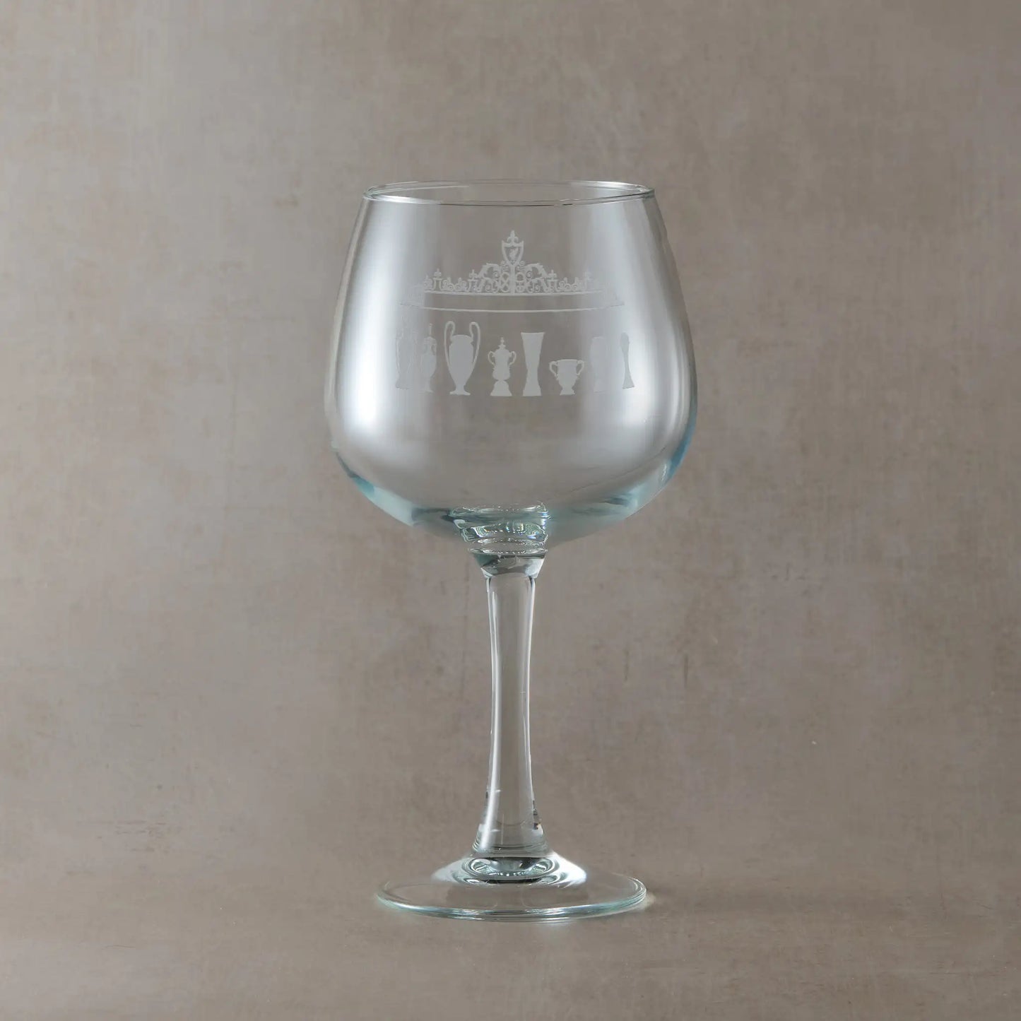 Engraved Liverpool gin glass with Shankly Gates and trophy silhouettes, shown on a beige background 