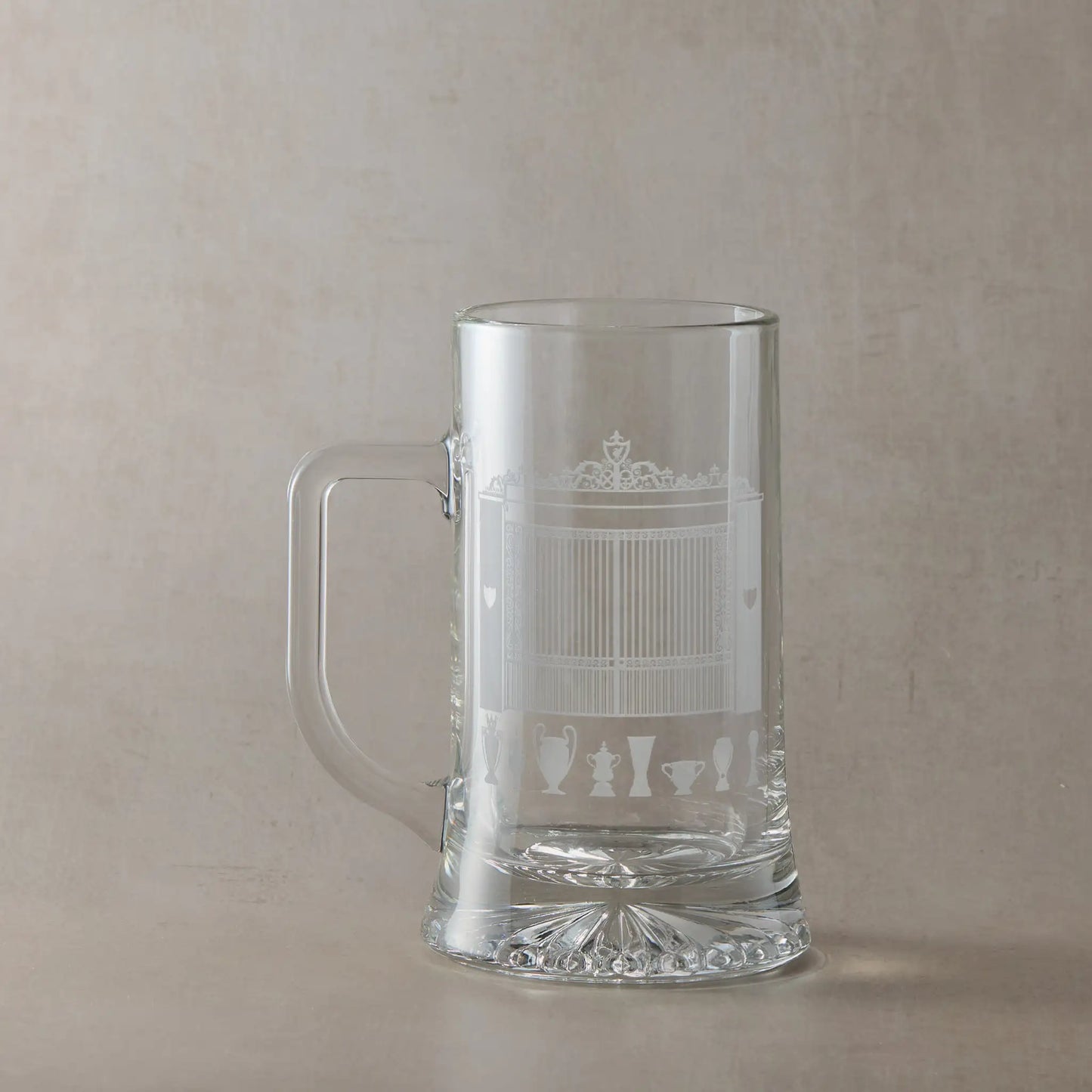 Clear glass tankard with engraved Anfield Stadium design on a beige background