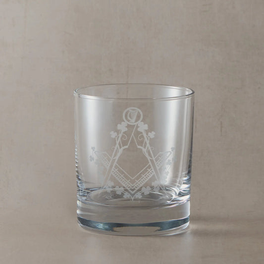 Engraved Irish Masonic whiskey glass with Square & Compass, shamrocks, and harp on black background