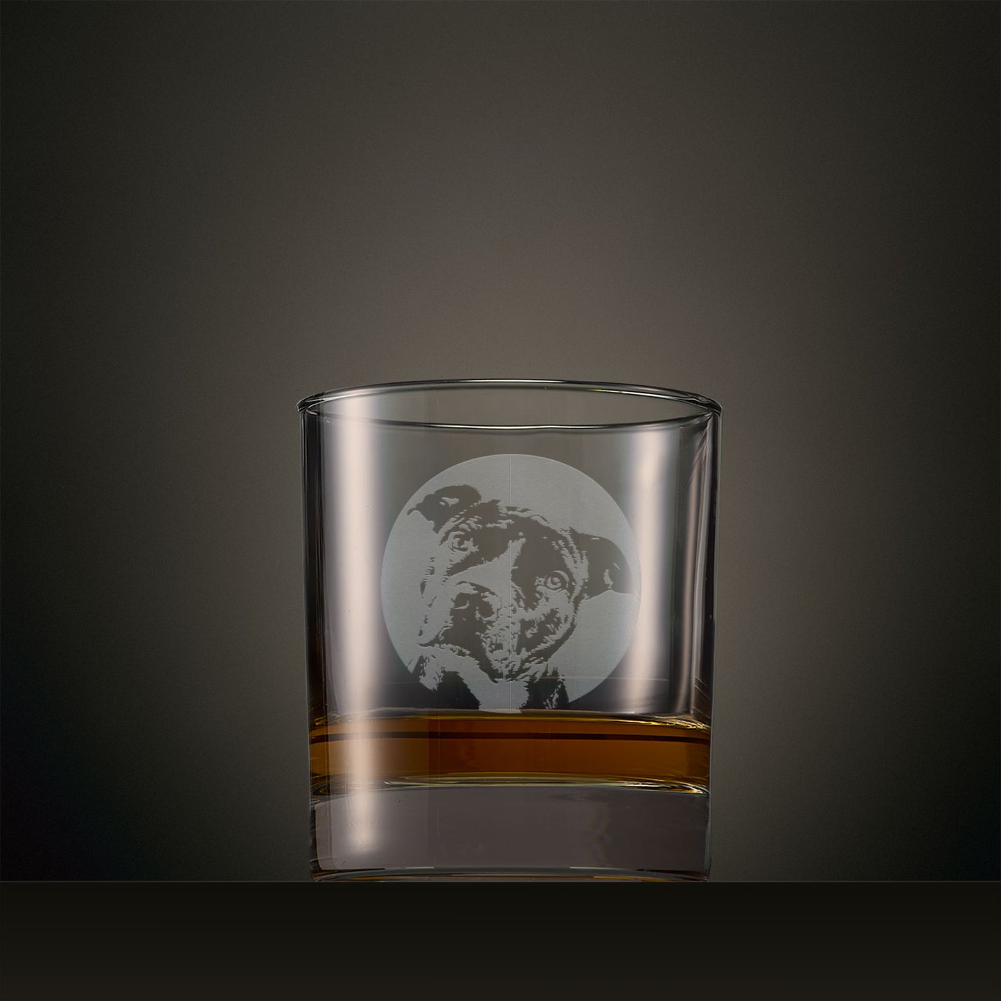 Engraved whisky glass featuring a Staffie portrait set within a circular design, photographed on a studio background