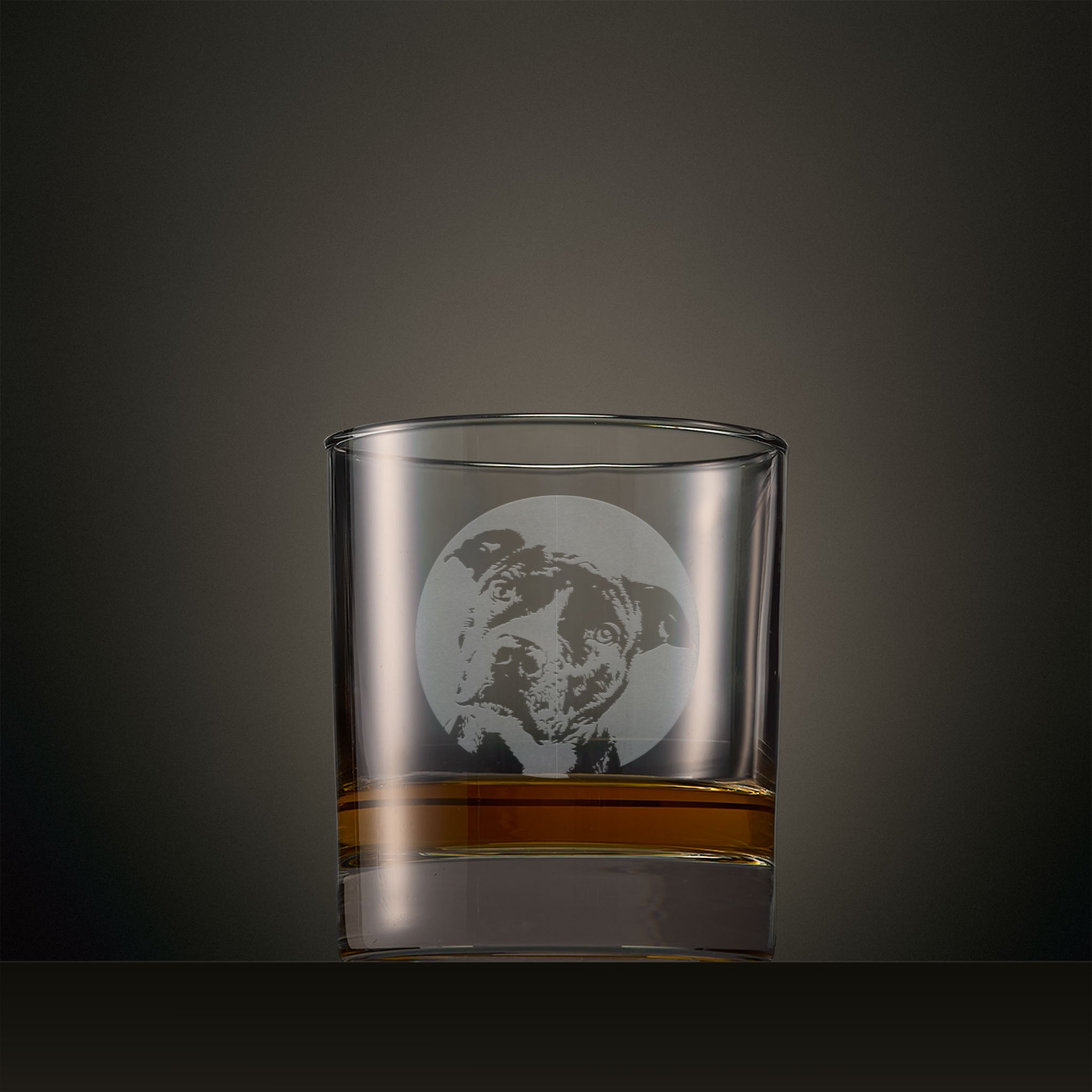 Engraved whisky glass featuring a Staffie portrait set within a circular design, photographed on a studio background