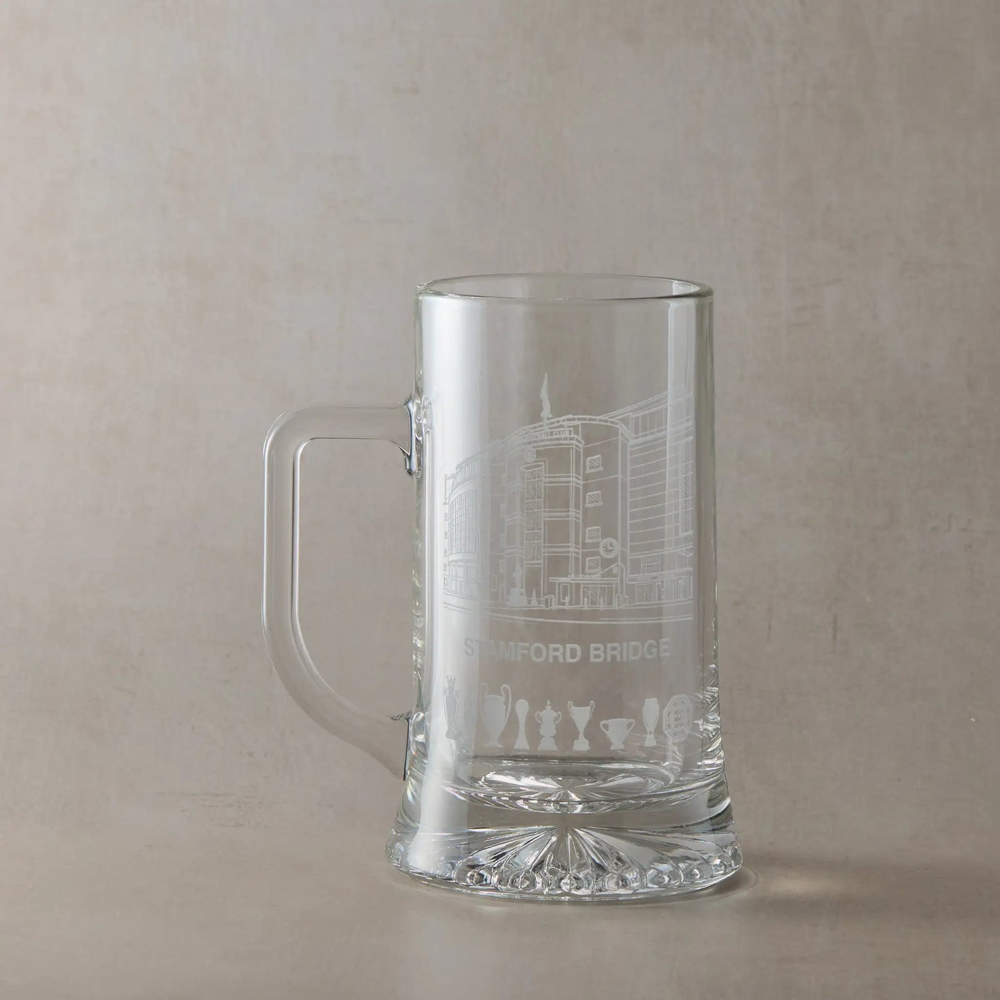Clear glass tankard engraved with Stamford Bridge stadium in Chelsea, shown against a pale background.