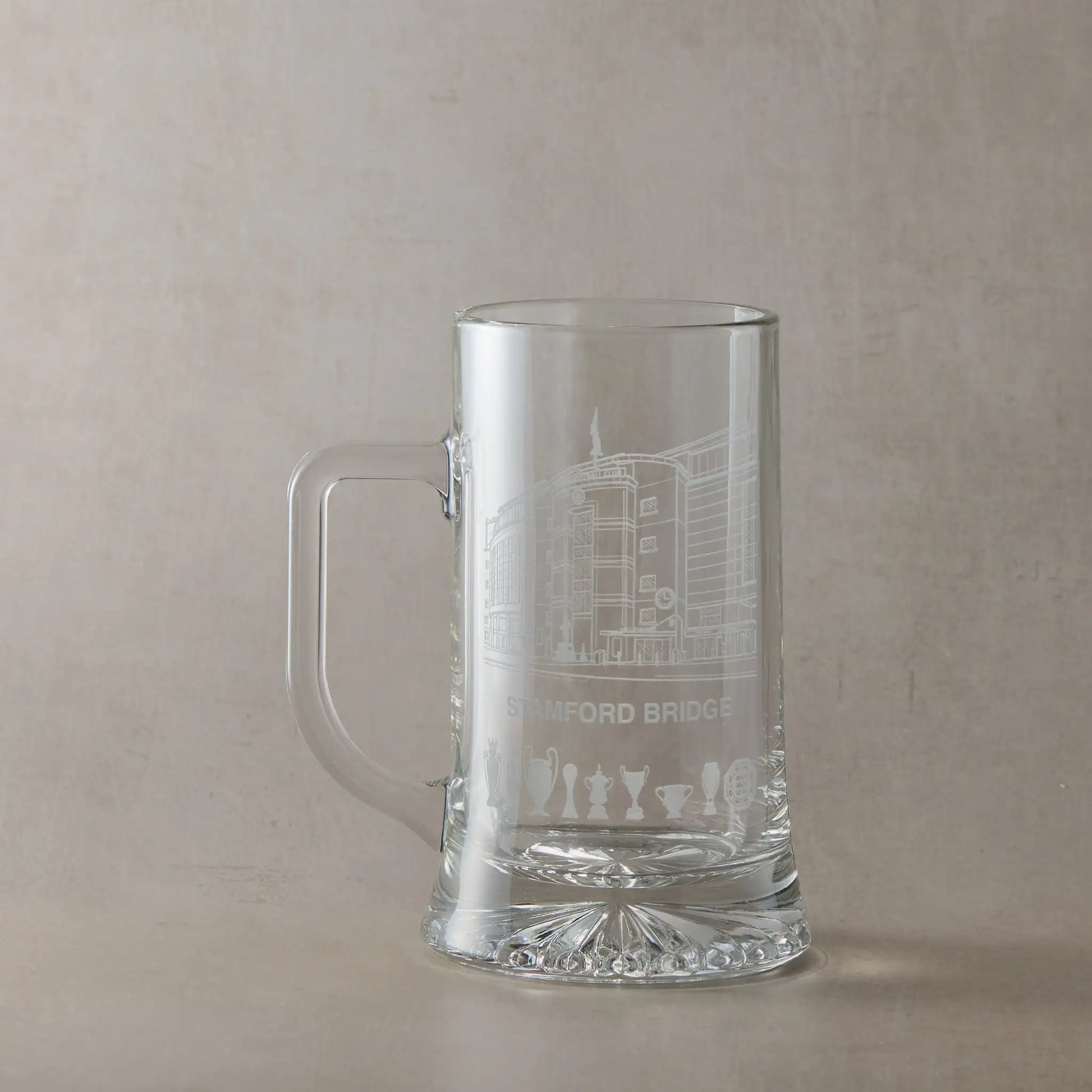 Clear glass tankard engraved with Stamford Bridge stadium in Chelsea, shown against a pale background.