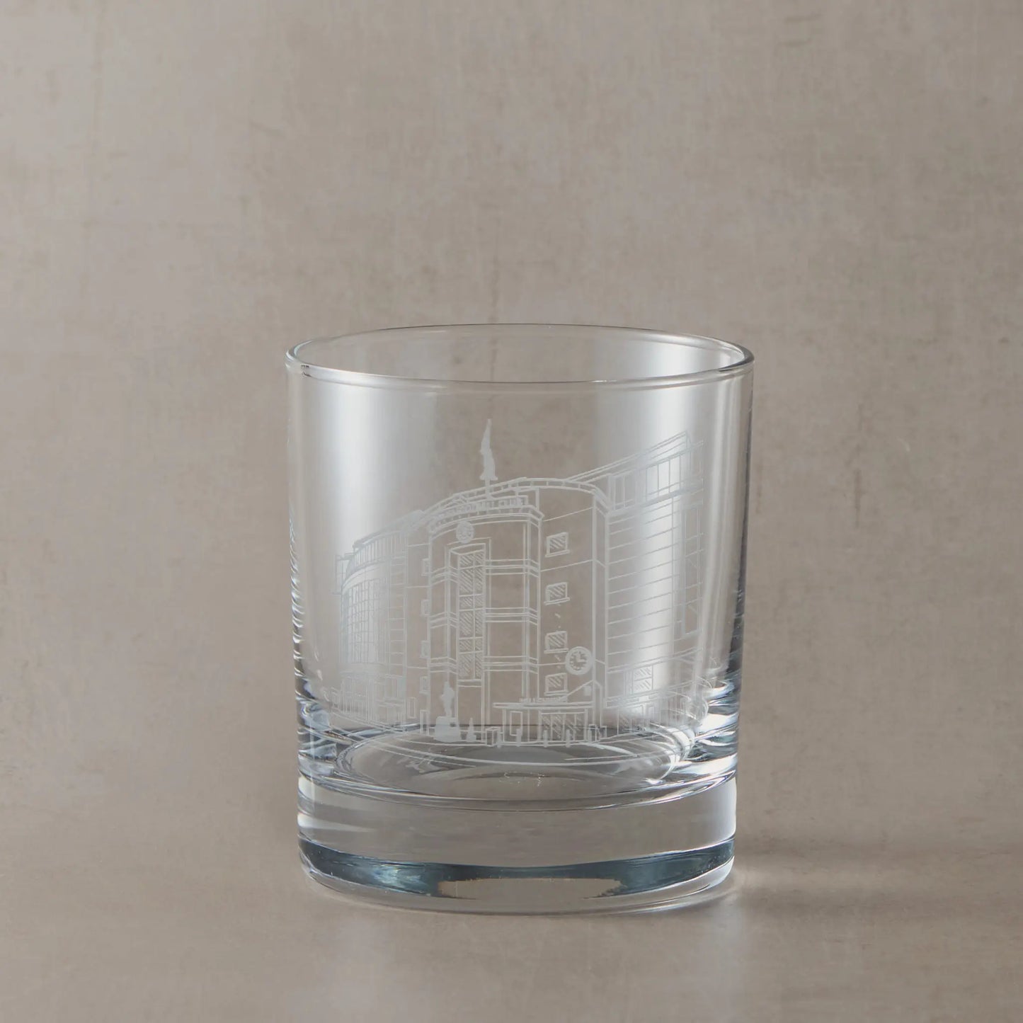 Engraved whisky glass with Stamford Bridge Stadium, shown on a beige background