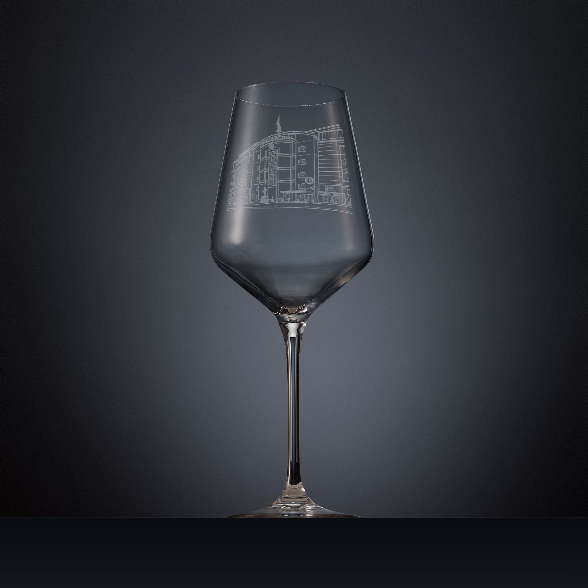 Engraved wine glass featuring a line-art illustration of Stamford Bridge stadium, shown on a dark background