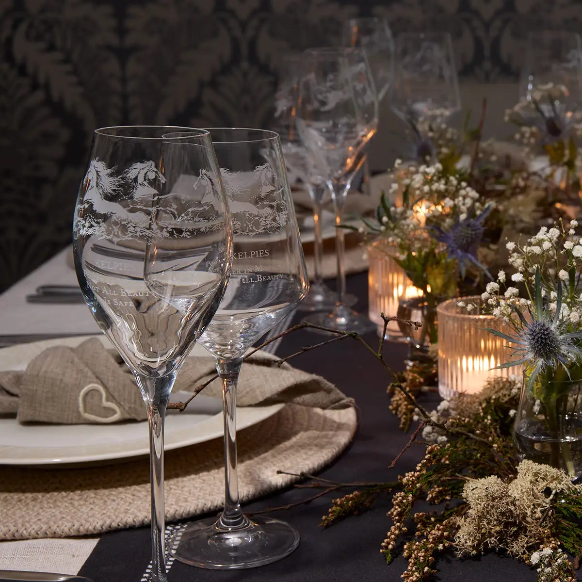 Tablescape laid with thistles, proseccos glasses and wine glasses