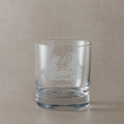 Whisky glass engraved with Suilven mountain shown on a beige background
