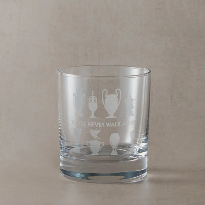 Personalised whisky glass engraved with honours wall trophy silhouettes and liverbird photographed on a beige background