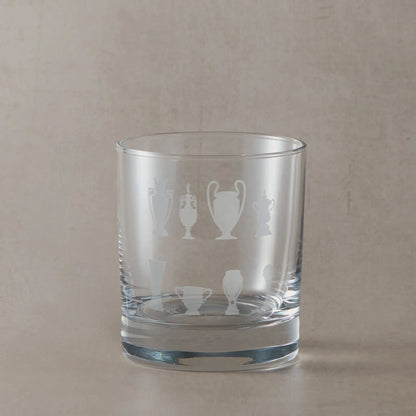 Personalised whisky glass engraved with honours wall eight trophy silhouettes photographed on a beige background
