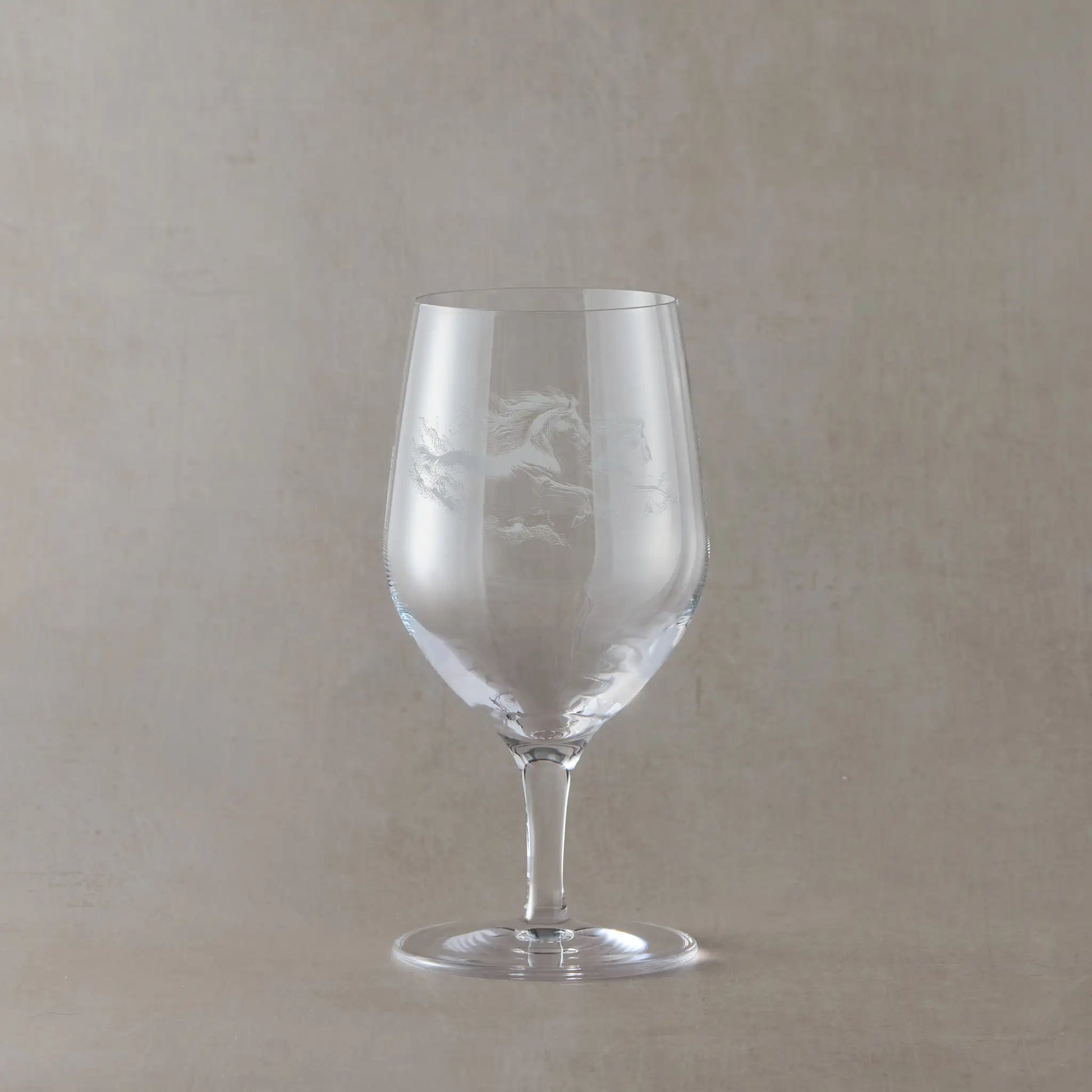 Mineral water glass engraved with two unicorns, shown on a pale background