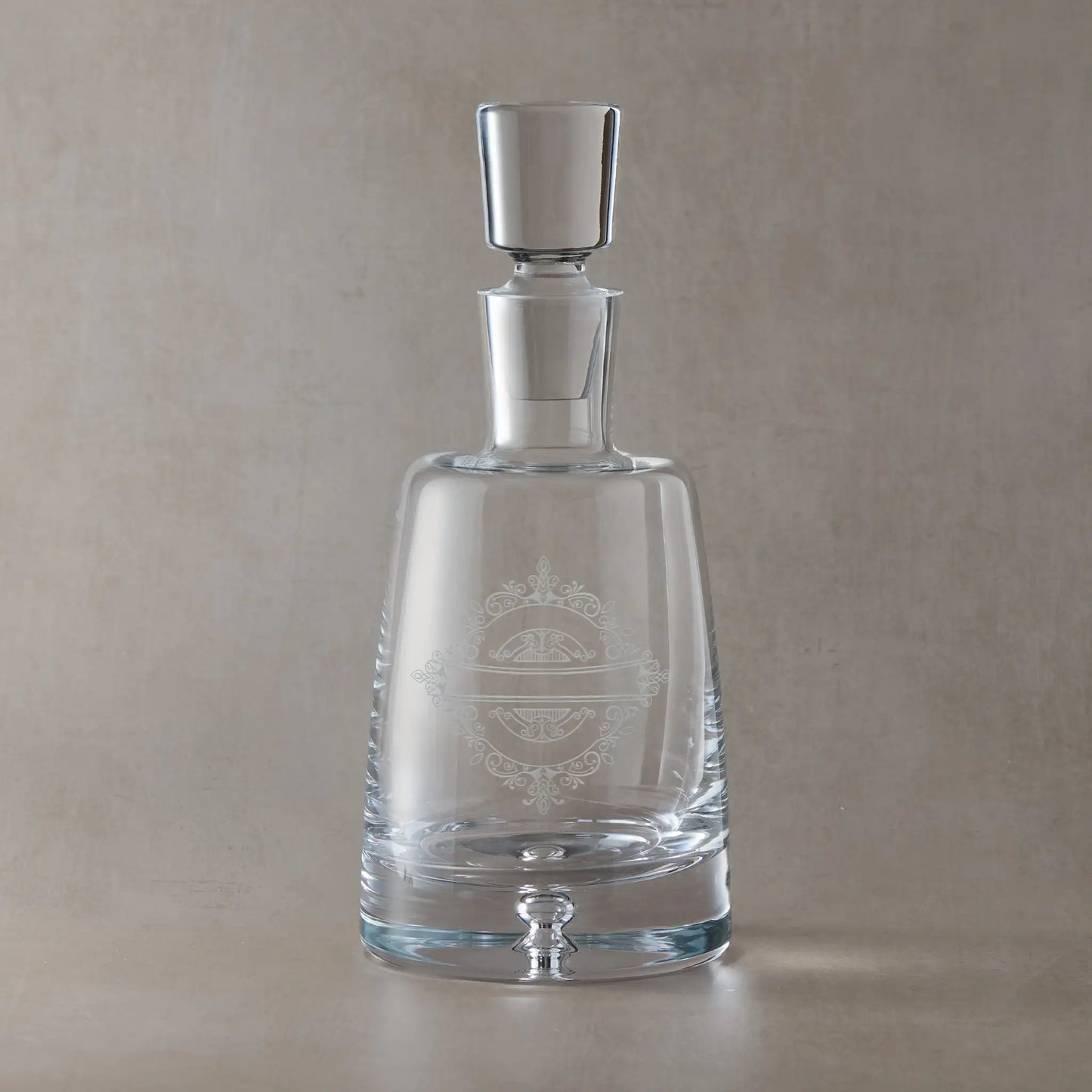 Handmade decanter engraved with venetian lacework design shown on a beige background