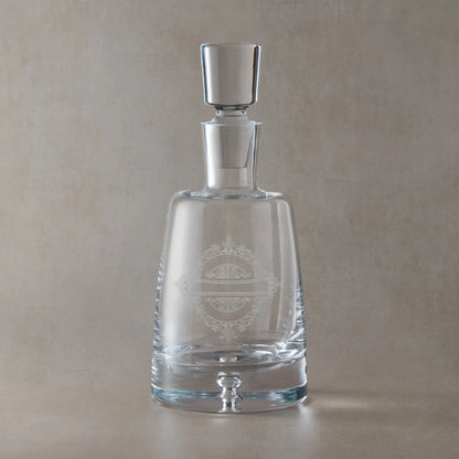 Handmade decanter engraved with venetian lacework design shown on a beige background