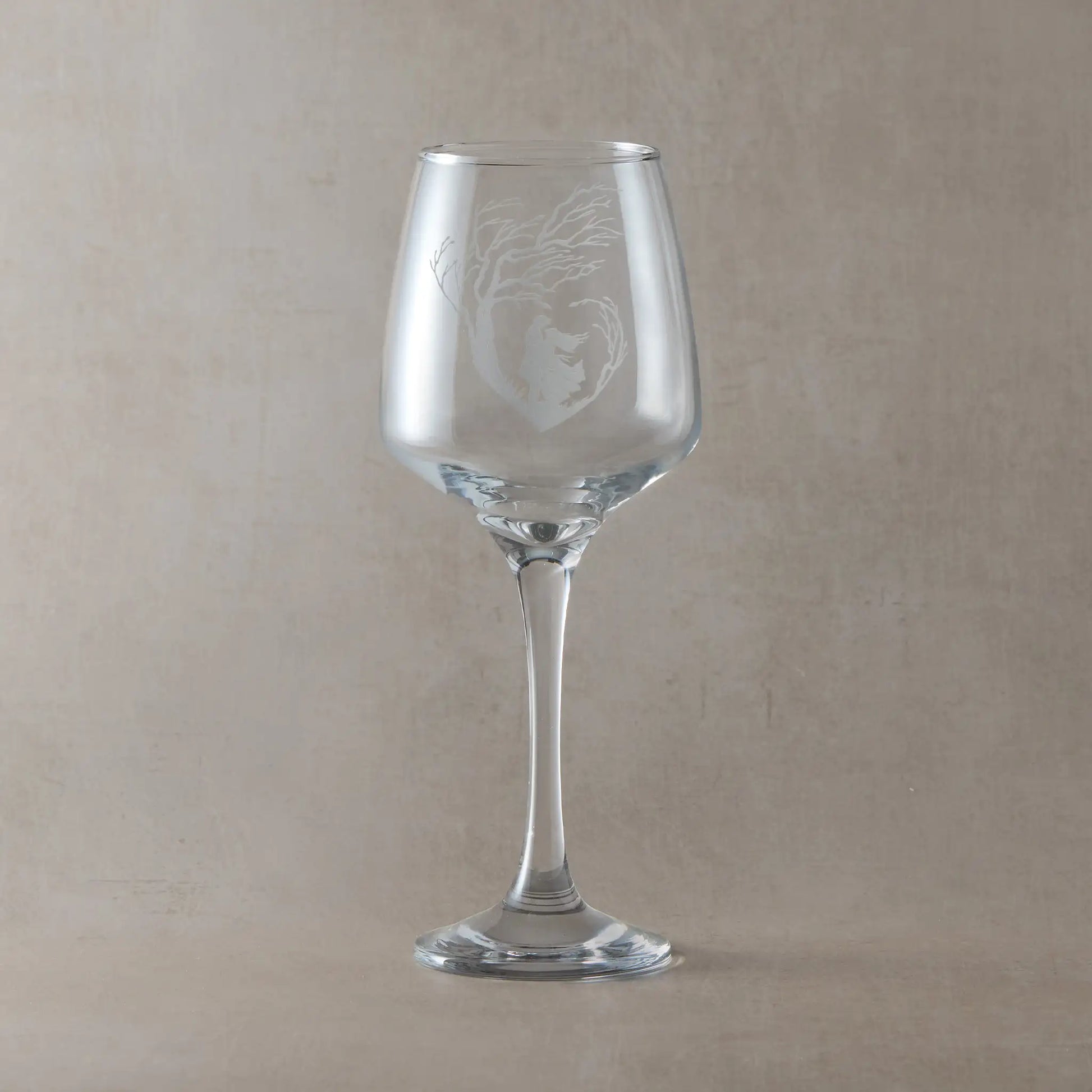 Engraved wine glass engraved with an  illustration of Cathy and Heathcliff embracing under a tree.
