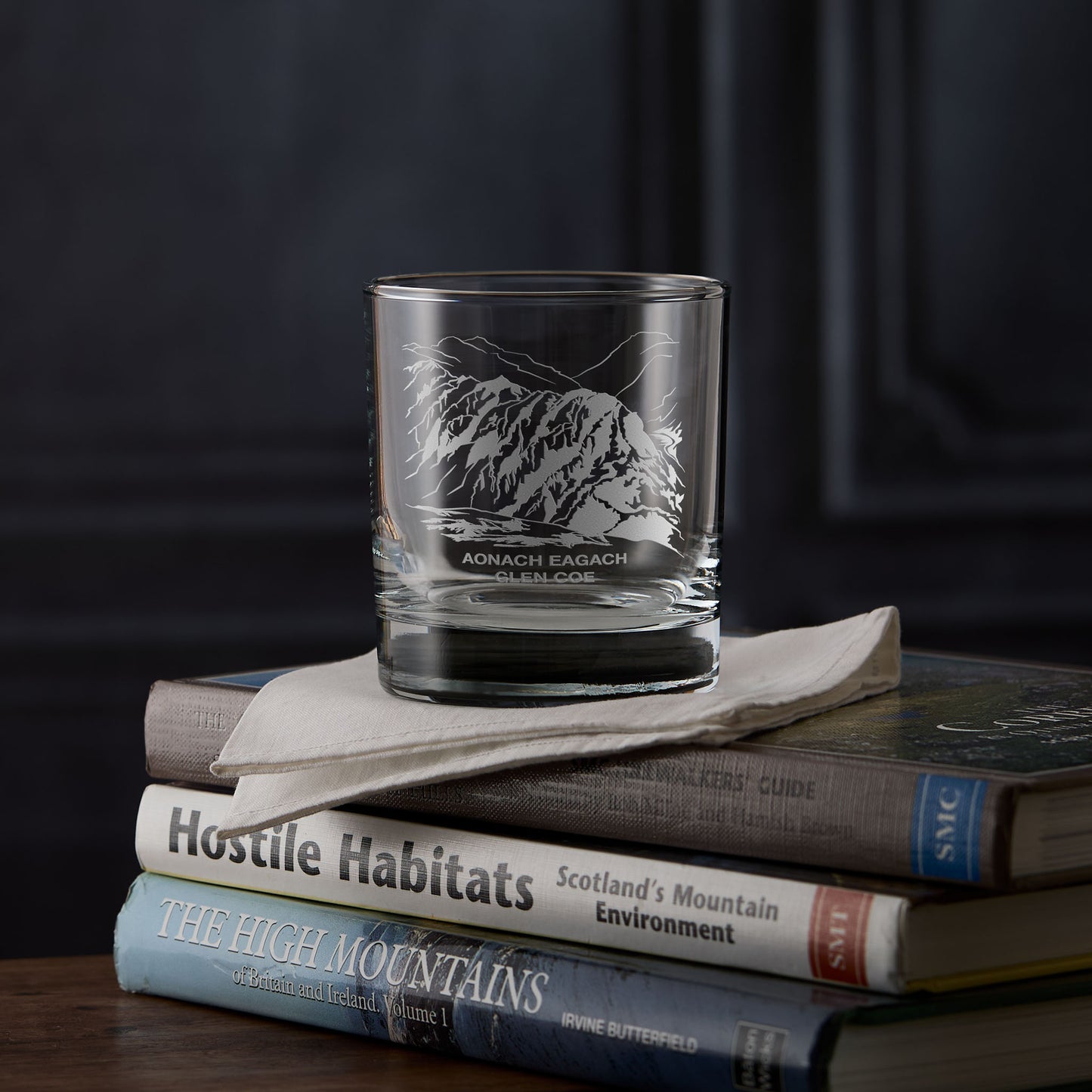 Aonach Eagach whisky glass engraved with the Glen Coe ridge, photographed on hillwalking books.