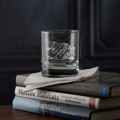 Aonach Eagach whisky glass engraved with the Glen Coe ridge, photographed on hillwalking books.