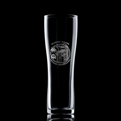 Engraved arcade pint glass with retro cabinet design, photographed on a black background to highlight engraving details.