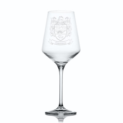Clear wine glass with an engraved crest on a white background