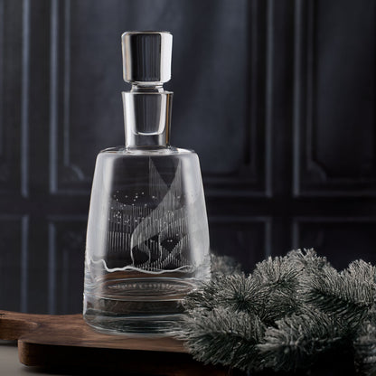 Hand-engraved glass decanter featuring an Aurora Borealis design on a dark background.