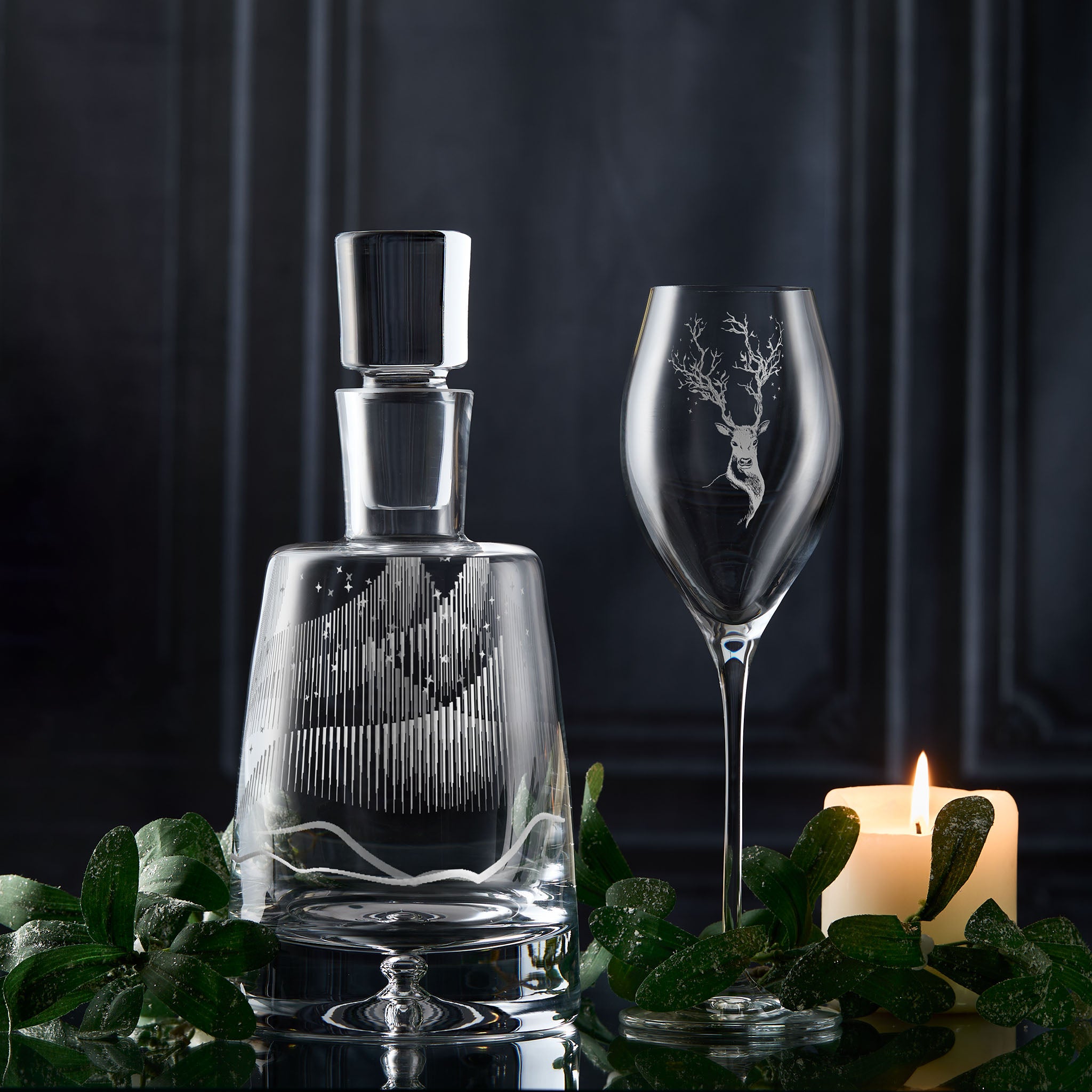 Aurora Borealis engraved decanter with leaping deer prosecco glass on a dark background.