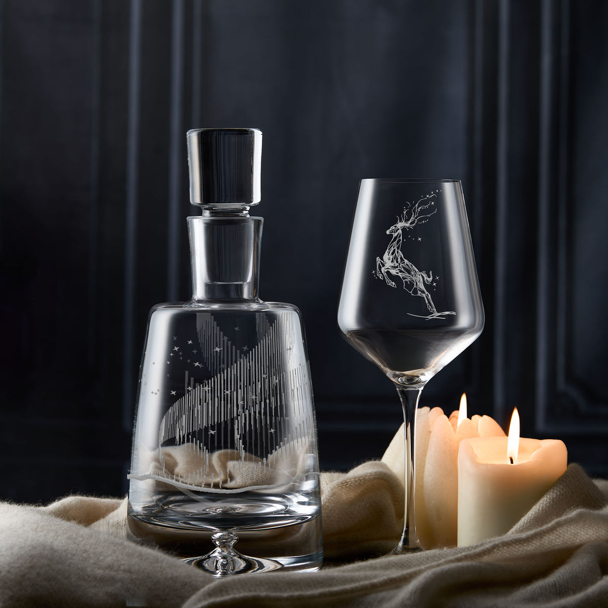 Aurora Borealis decanter and engraved leaping stag wine glass on a dark background.