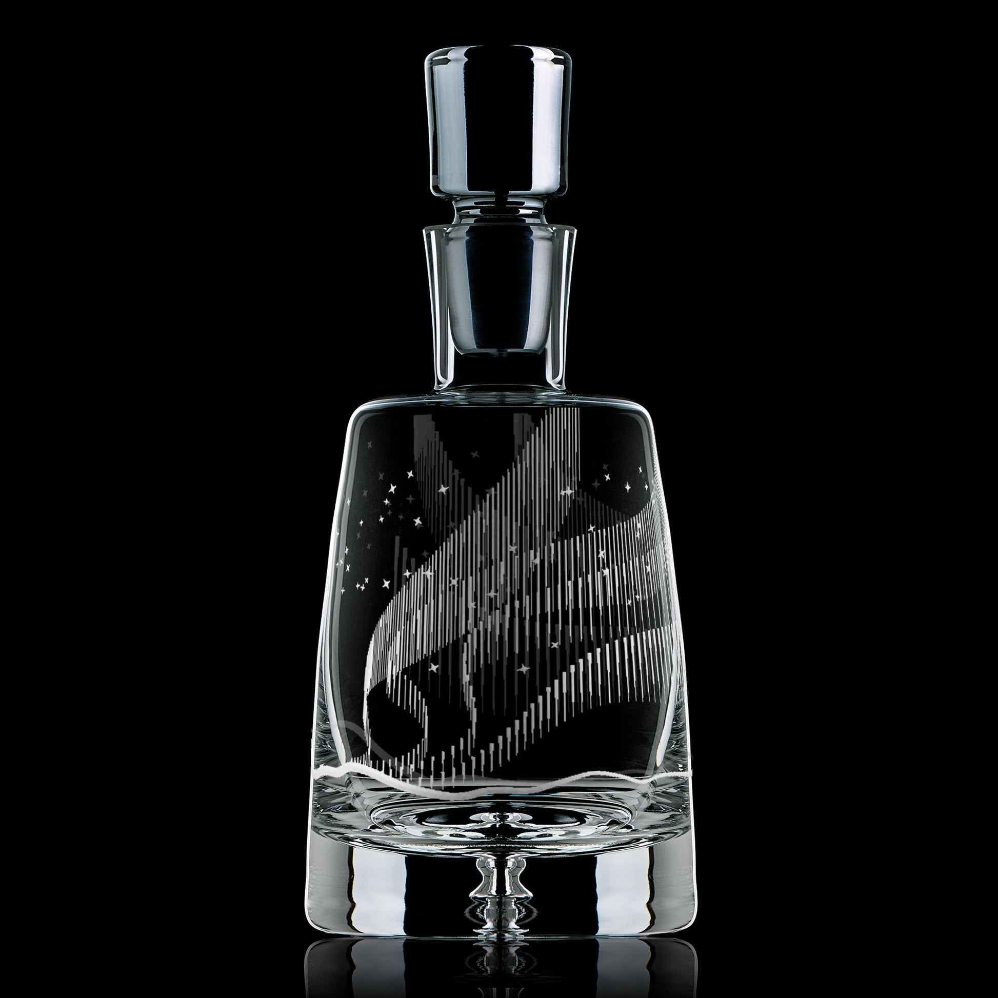 Glass decanter engraved with an Aurora Borealis design on a black background.