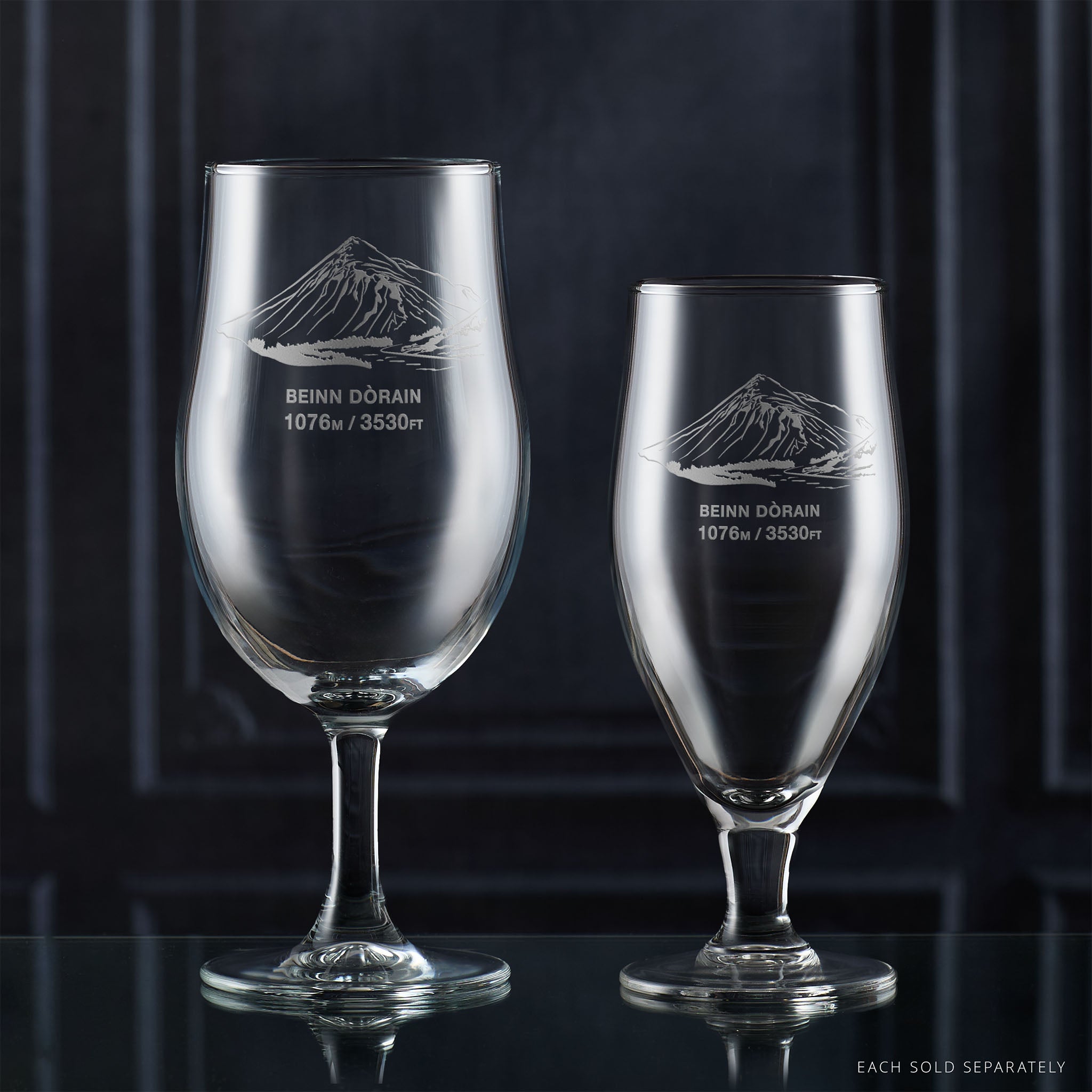 Pair of stemmed beer glasses engraved with Beinn Dorain, photographed on a reflective surface