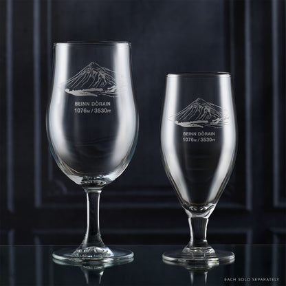 Pair of stemmed beer glasses engraved with Beinn Dorain, photographed on a reflective surface