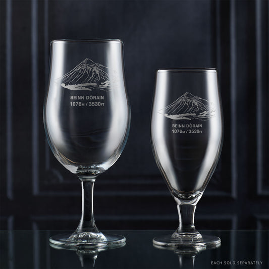 Pair of stemmed beer glasses engraved with Beinn Dorain, photographed on a reflective surface
