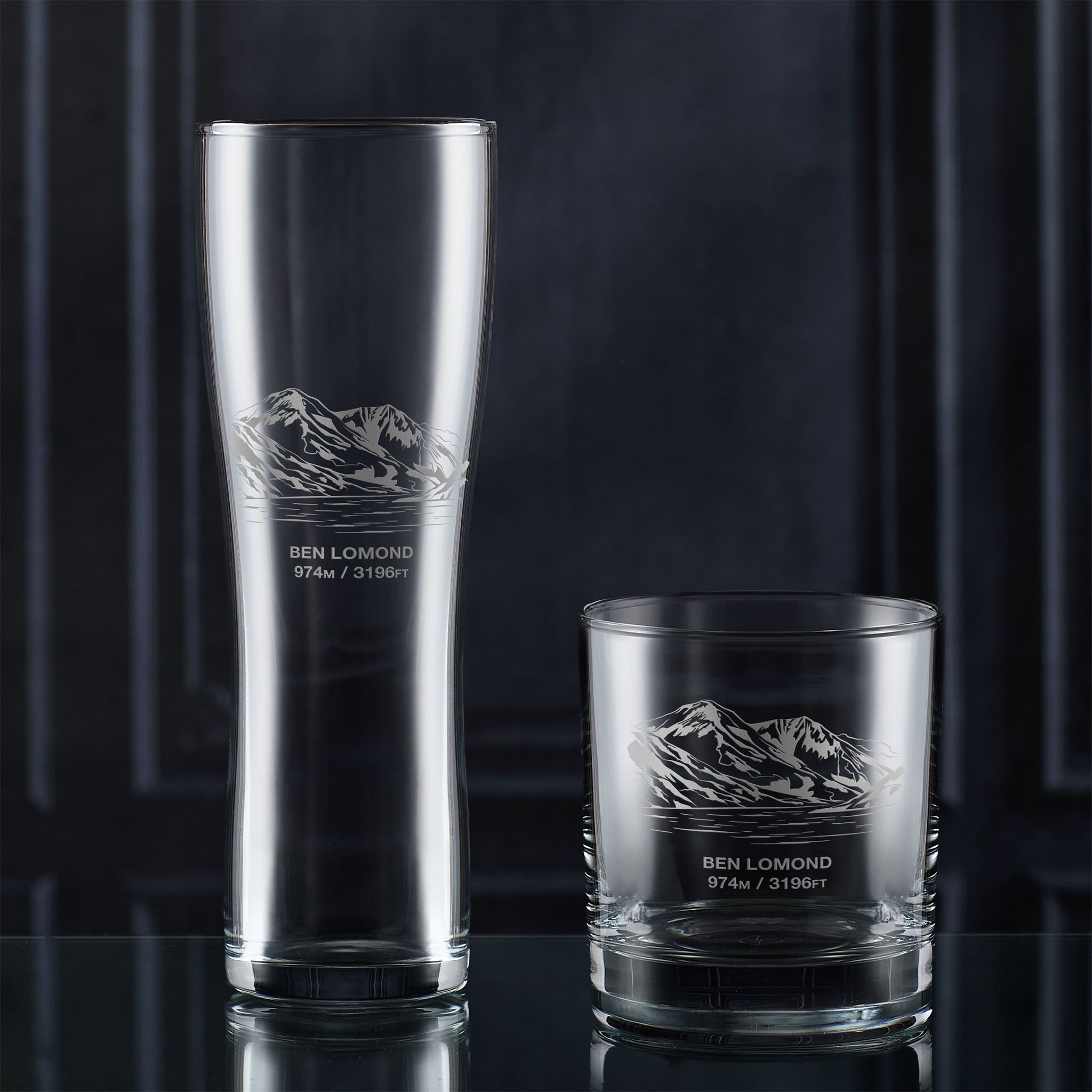 Pint and whisky glass engraved with Ben Lomond, photographed together on a dark background