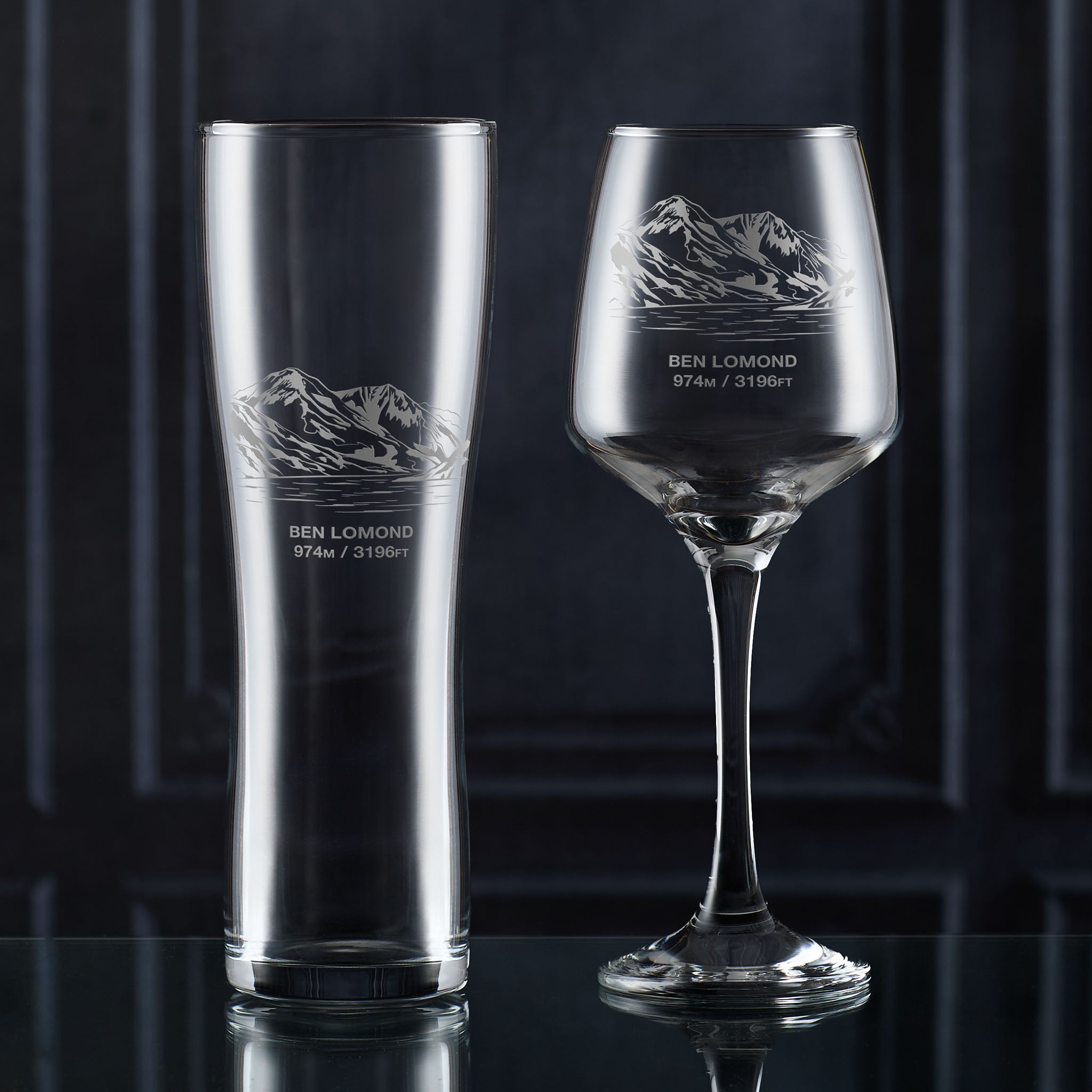Pint glass and wine glass engraved with Ben Lomond, photographed on a dark background