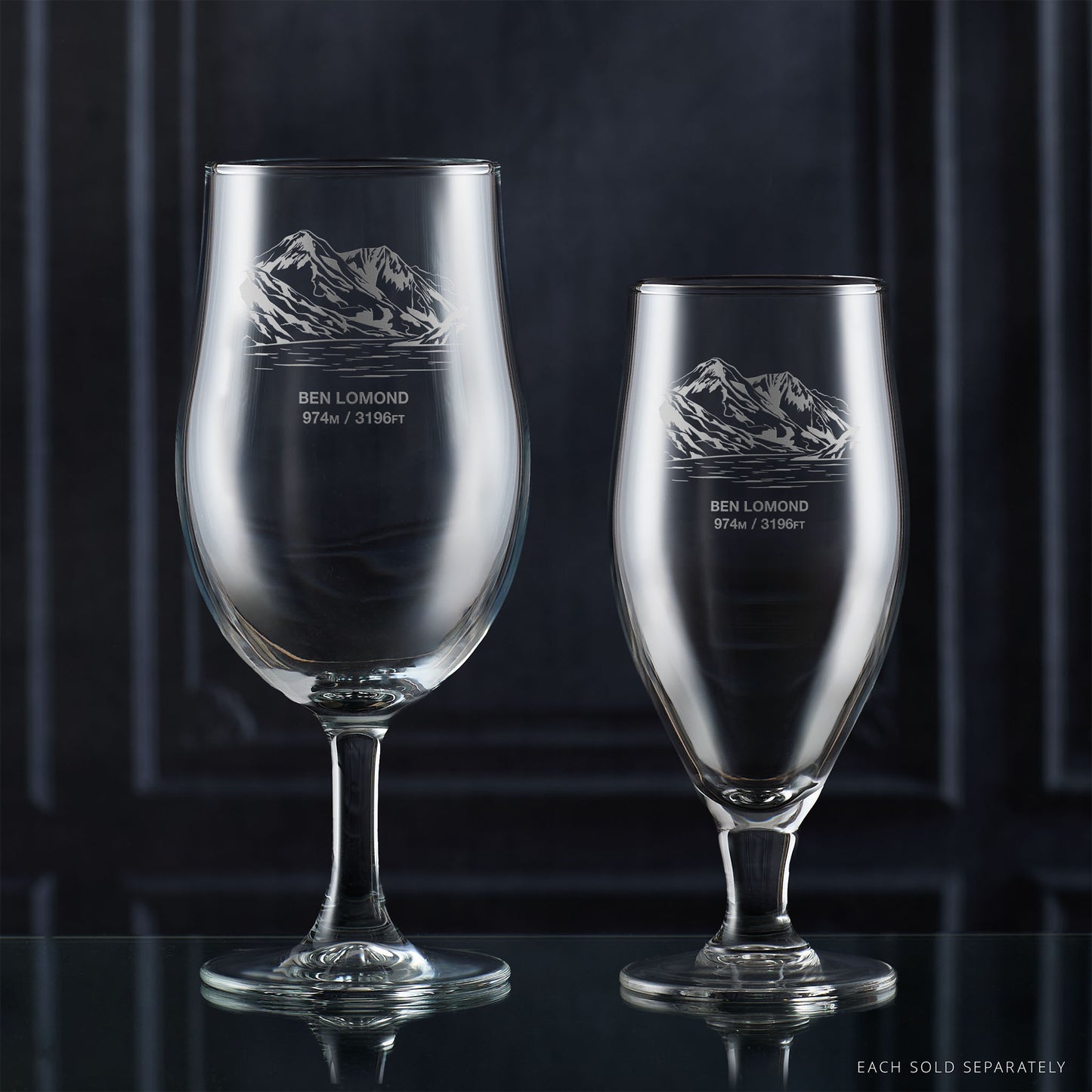 Pair of stemmed beer glasses engraved with Ben Lomond on a reflective surface