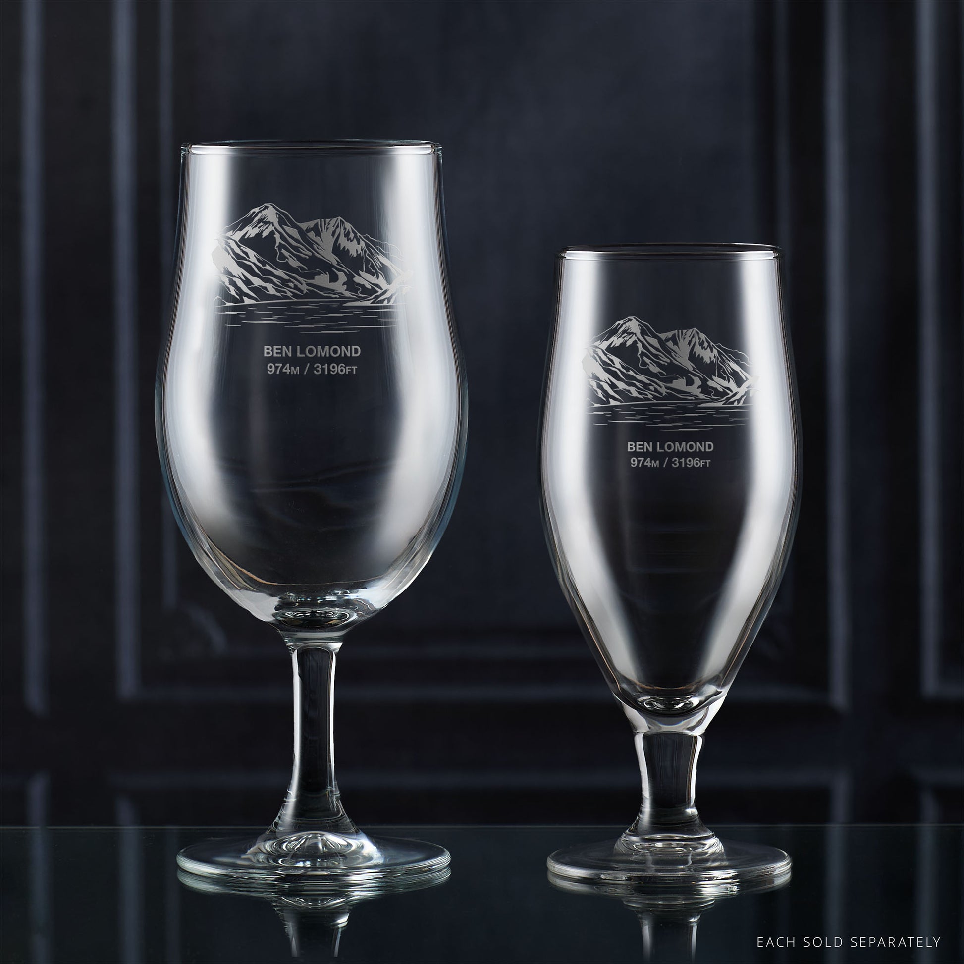Pair of stemmed beer glasses engraved with Ben Lomond on a reflective surface